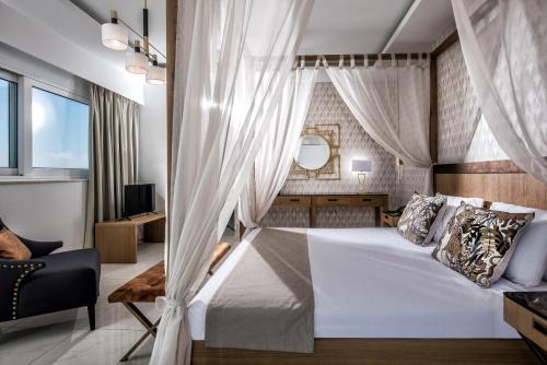 een slaapkamer met een groot bed met gordijnen bij Hotel Matheo Villas & Suites in Malia