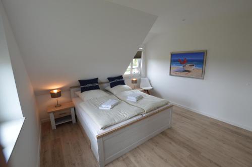 a small bedroom with a bed with white sheets and blue pillows at Stadthaus 4, inkl 1 Parkplatz in Burg auf Fehmarn