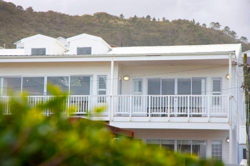 a white house with a porch and a balcony at Beach House 11A in Groot Brak Rivier