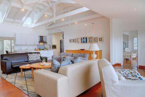 a living room with a couch and a table at Beach House 11A in Groot Brak Rivier
