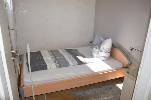 małe łóżko z dwoma poduszkami na górze w obiekcie Ferienwohnung Borken w mieście Bad Salzungen