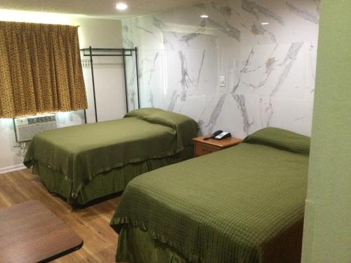 a room with two beds and a wall withigraphy at Americas Express Inn Rocky Mount in Rocky Mount