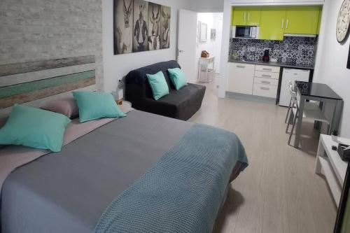 een slaapkamer met een groot bed en een bank bij Apartamento con piscina a 2 minutos de la playa!!! in Lloret de Mar