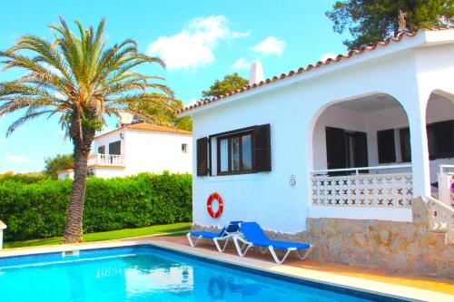 a villa with a swimming pool in front of a house at Villa Celia in Son Bou