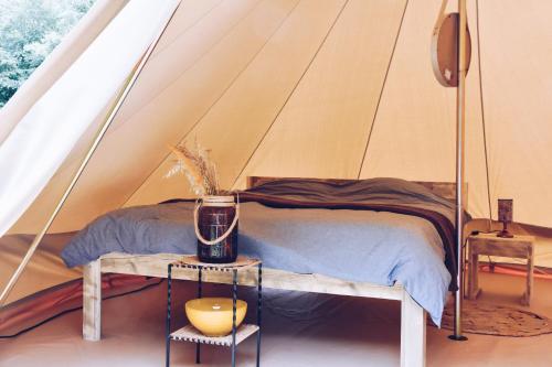 une chambre avec un lit dans une tente dans l'établissement Les Insolites du Domaine d'Haulmé, à Haulmé