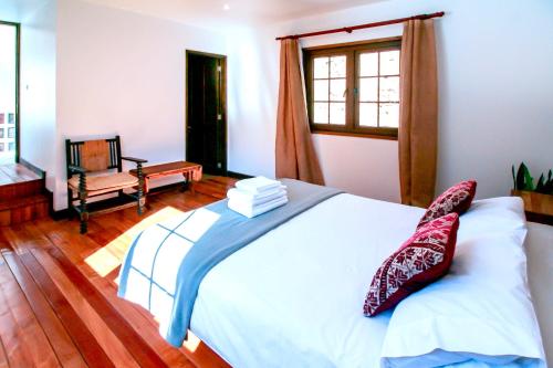 a bedroom with a white bed and a window at Casa California Guesthouse in Valparaíso