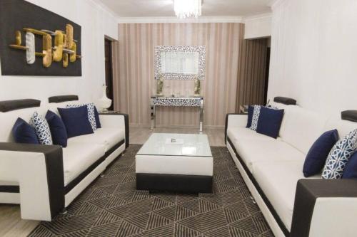 a living room with two white couches and a table at 8 Bedrooms Penthouse Jacuzzi & Private Terrace in Santo Domingo
