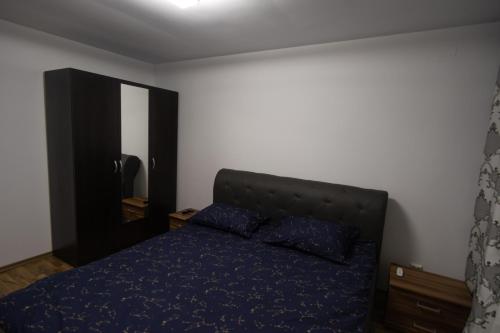 a bedroom with a bed with blue sheets and a mirror at Aquarium Apartment in Buzău