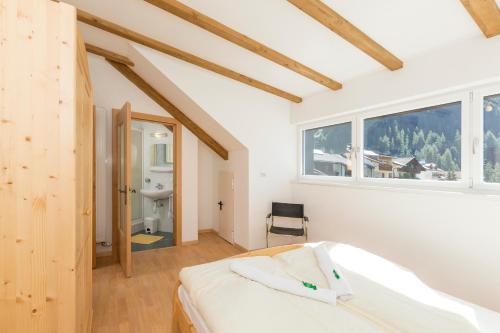 a bedroom with a white bed and a window at Appartement Sonneck in Lappago