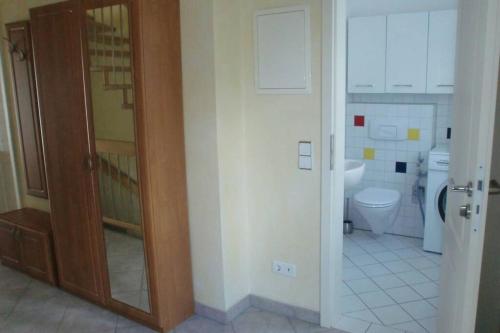 ein Badezimmer mit Toilette und Glastür in der Unterkunft Oase im Dresdner Westen in Dresden