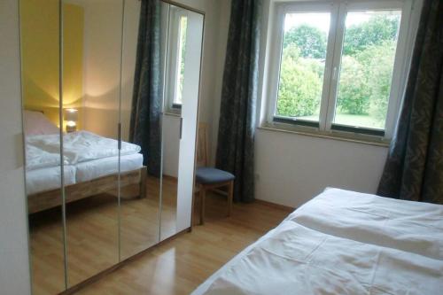 1 Schlafzimmer mit einem Spiegel, 2 Betten und einem Fenster in der Unterkunft Oase im Dresdner Westen in Dresden