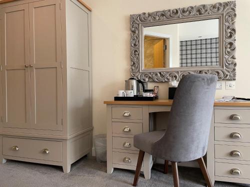 a bedroom with a desk and a mirror and a chair at Boston West Hotel in Boston