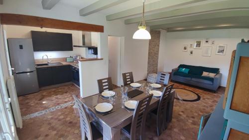 une cuisine et une salle à manger avec une table et des chaises dans l'établissement Maison 400m Océan avec jardin clos et ombragé, à Saint-Georges-dʼOléron