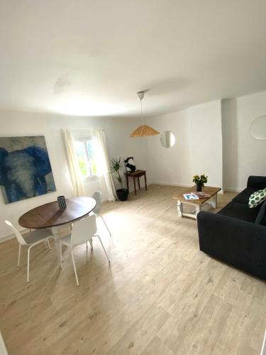 un salon avec un canapé noir et une table dans l'établissement Il y a le Soleil, la Campagne et la Mer, à Martigues