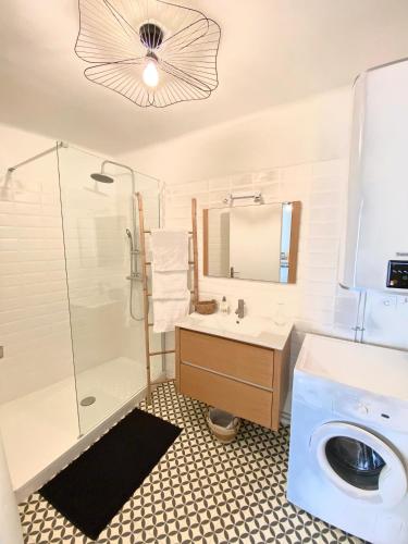 une salle de bain avec un lavabo et une machine à laver dans l'établissement Il y a le Soleil, la Campagne et la Mer, à Martigues