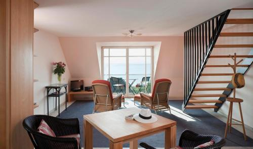 una sala de estar con una escalera de caracol y sillas en Kormoran, en Haffkrug