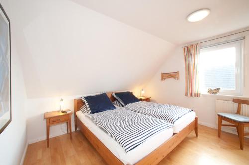 um quarto com uma cama e uma janela em Haus Gud Hööb Whg 06 em Wyk auf Föhr