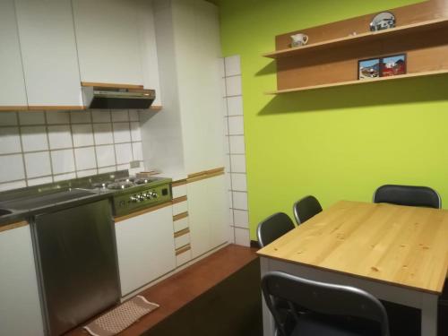 een keuken met een houten tafel en groene muren bij casa del lago Lesa in Lesa