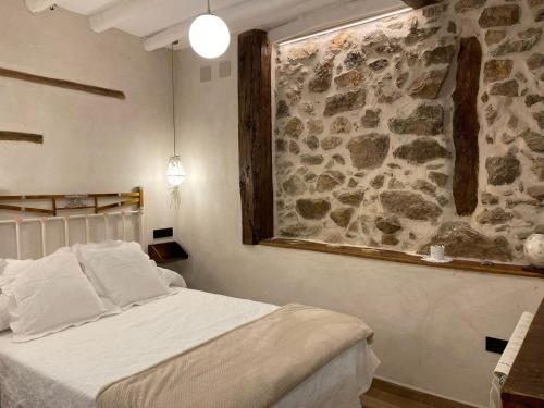 a bedroom with a stone wall and a bed at Apartamento La Herrerita in Candelario