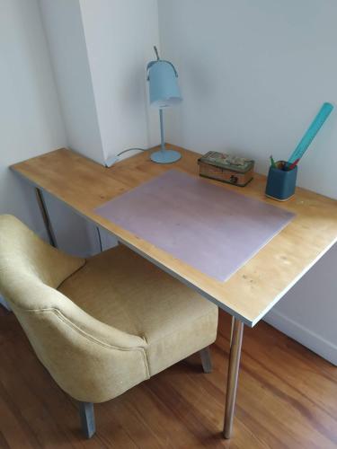 a wooden desk with a chair and a lamp at Gîte Moishan in Mouchan