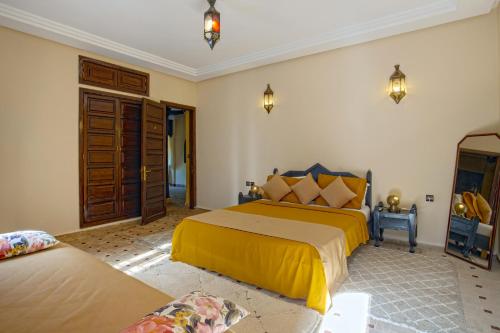 a bedroom with two beds with yellow sheets at Riad Dar Biona Maison D'hôtes & Spa in Aït Zat