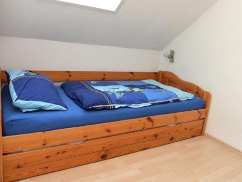 Bett mit blauer Bettwäsche und blauen Kissen in einem Zimmer in der Unterkunft Fewo 91 WHG C 21 in Burhave in Burhave