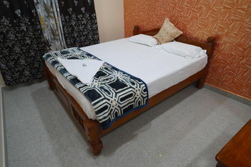 a bedroom with a bed with a laptop on it at Akash homestay in Hampi