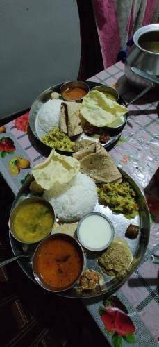 a plate of food with different types of food on a table at Akash homestay in Hampi