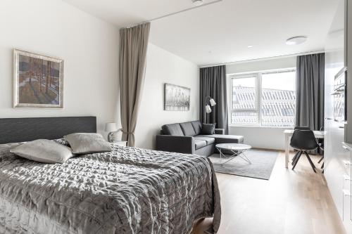 - une chambre avec un lit et un salon dans l'établissement ARENA Junior Suite, à Tampere