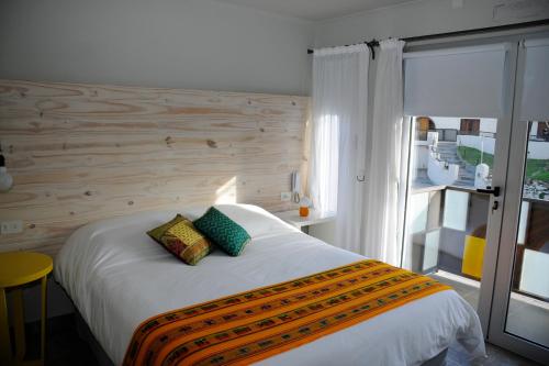1 dormitorio con 1 cama con pared de madera en Azar Departamentos Tandil en Tandil