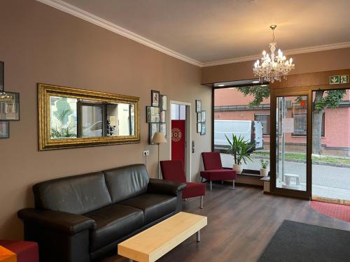 a living room with a leather couch and a mirror at Hafner Hotel Apartment Self Check-In Anytime in Stuttgart