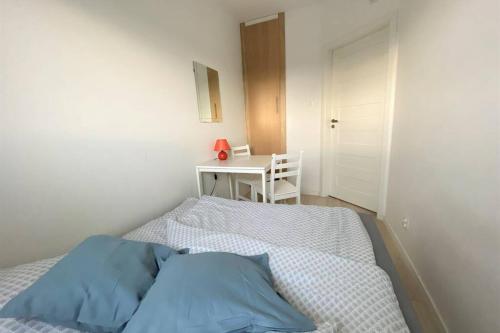 a bedroom with a bed and a table and a desk at Homely Apartment in Gdańsk
