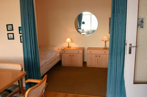 - une chambre avec un lit, deux commodes et un miroir dans l'établissement Jenatschek, FP, N-1-2, à Heiligenhafen