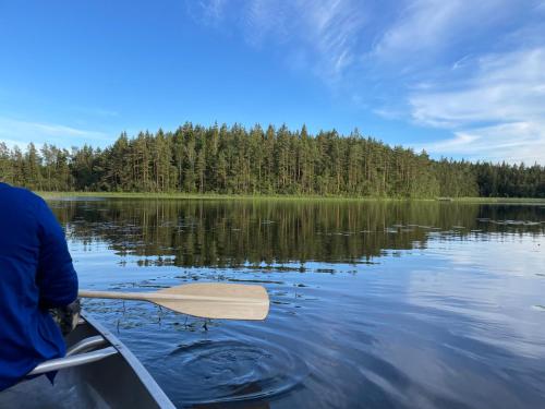 a person is paddling a canoe on a lake at Gråbogården event and conference center in Gråbo