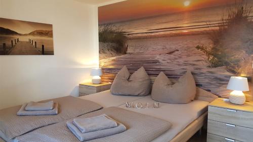 a bedroom with two beds and a painting on the wall at FeWo Aust in Sankt Peter-Ording