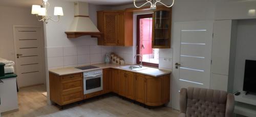 cocina con armarios de madera, fregadero y ventana en Chata Spaní na peci, en Mikulovice