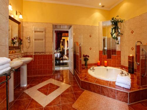 a large bathroom with a tub and a sink at Hotel Europejski in Kraków