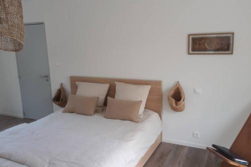 a bedroom with a bed with white sheets and pillows at Parenthèse nature in Soultz-Haut-Rhin