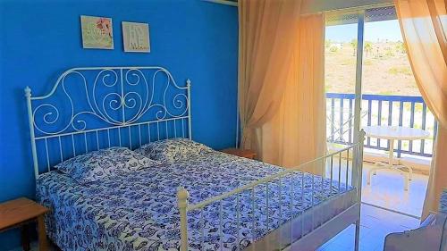 a blue bedroom with a bed and a balcony at 1 bedroom apartment with a magnificent sea view in Limassol