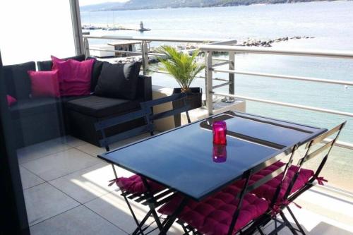 une table et des chaises sur un balcon avec vue sur l'eau dans l'établissement Appartement T2 terrasse vue mer à 180, à Propriano