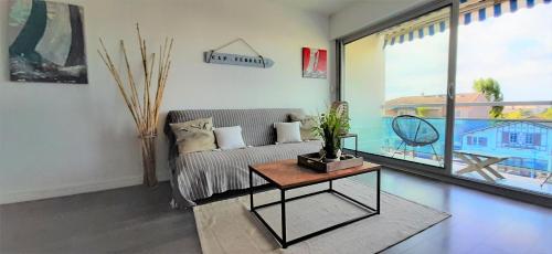 un salon avec un canapé et une table dans l'établissement Résidence Estey T2 centre avec aperçu Bassin, à Andernos-les-Bains