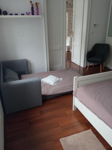 a bedroom with a bed and a couch and a chair at UBYTOVÁNÍ NA SPRÁVNÉM MÍSTĚ in Znojmo
