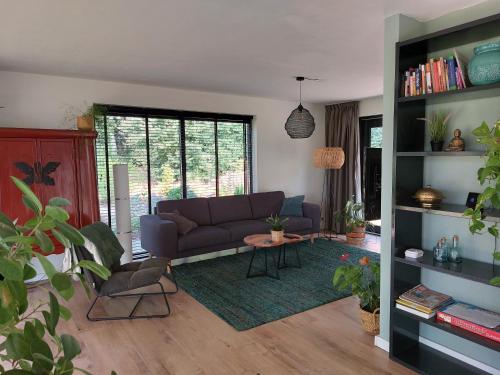 a living room with a purple couch and a table at Vakantiehuis met hottub en barrelsauna in Ommen