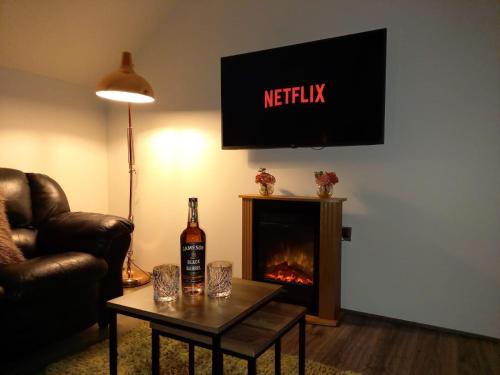 a living room with a bottle of wine and a fireplace at Ballymakeever Appartment - Private Hot Tub in Derry Londonderry