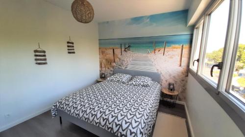 um quarto com uma cama e um quadro de um cais em Résidence Estey T2 centre avec aperçu Bassin em Andernos-les-Bains