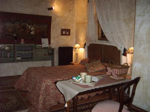 a bedroom with a bed and a table with a plate on it at Maison d'hôtes Ferme de la Commanderie in Richerenches
