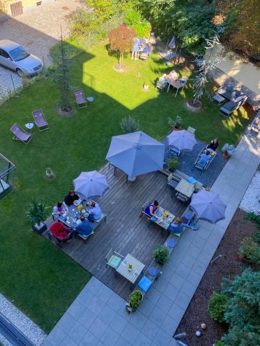 a group of people sitting at tables with umbrellas at Blackhome Graz I contactless check-in in Graz