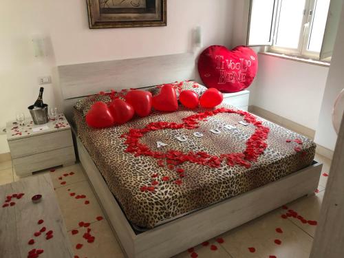 ein Bett mit einem Herz aus roten Kissen in der Unterkunft B&B Sophie in Neapel