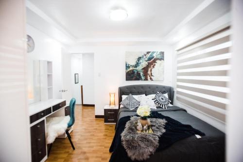 1 dormitorio con cama negra y escritorio en Bella Casa (3BR House at Azienda Genova) en Talisay
