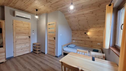 1 dormitorio con 1 cama y pared de madera en Wrzosowe Wzgórze en Chęciny